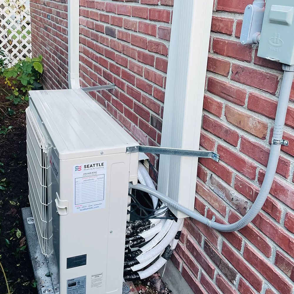 Mitsubishi Electric outdoor unit installed against a brick wall