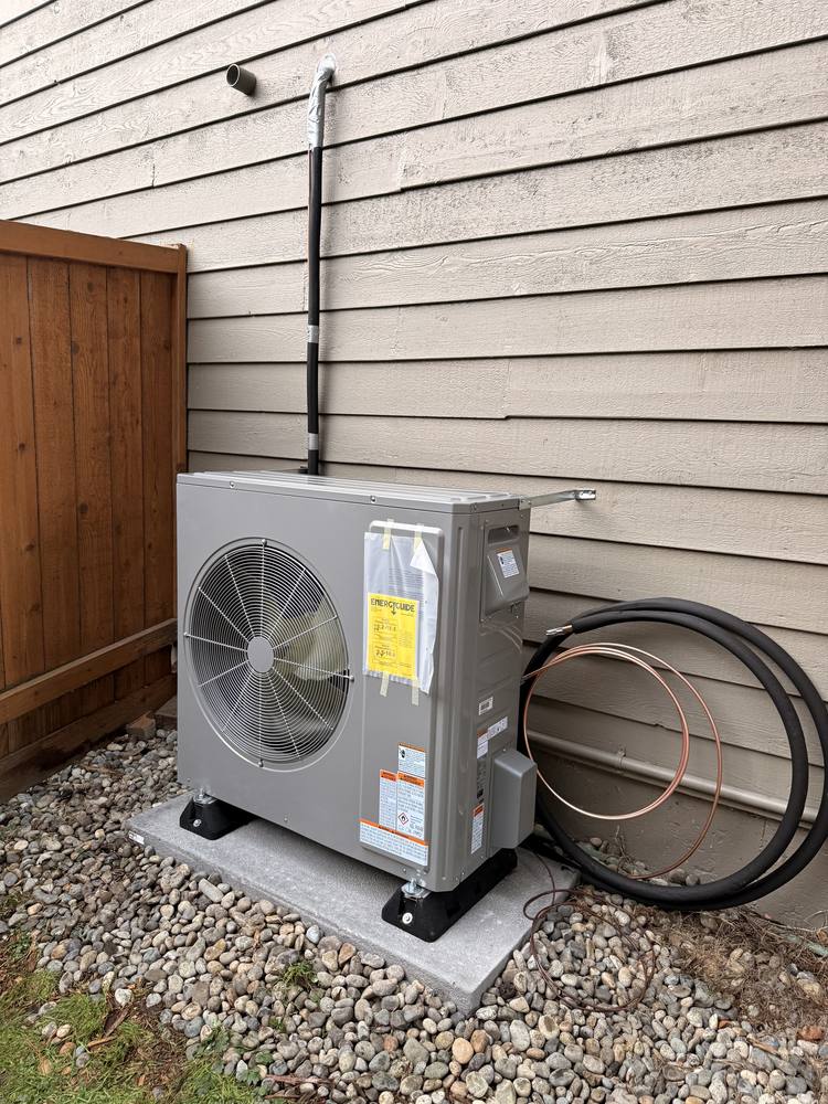 Heat pump outdoor unit installed on a gravel pad in Redmond