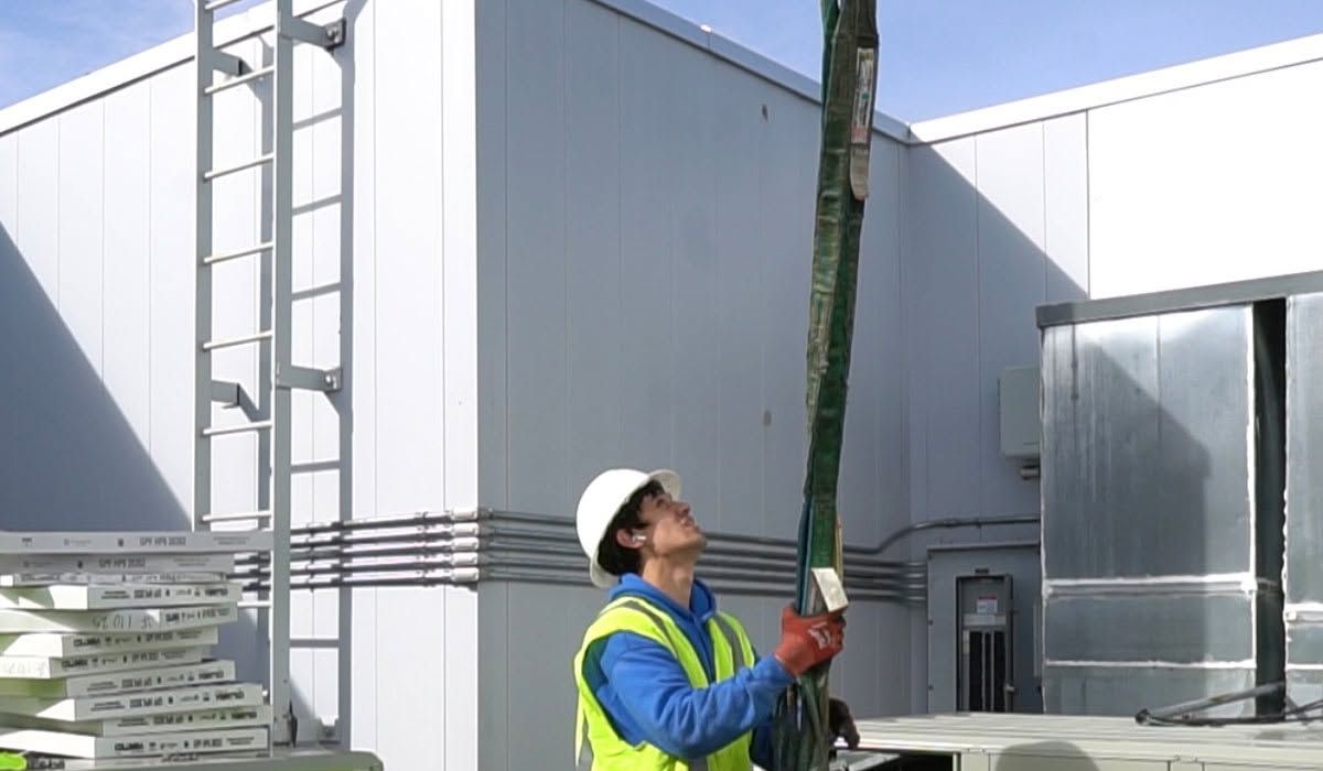 Seattle Heating & Cooling technician rigging new rooftop equipment